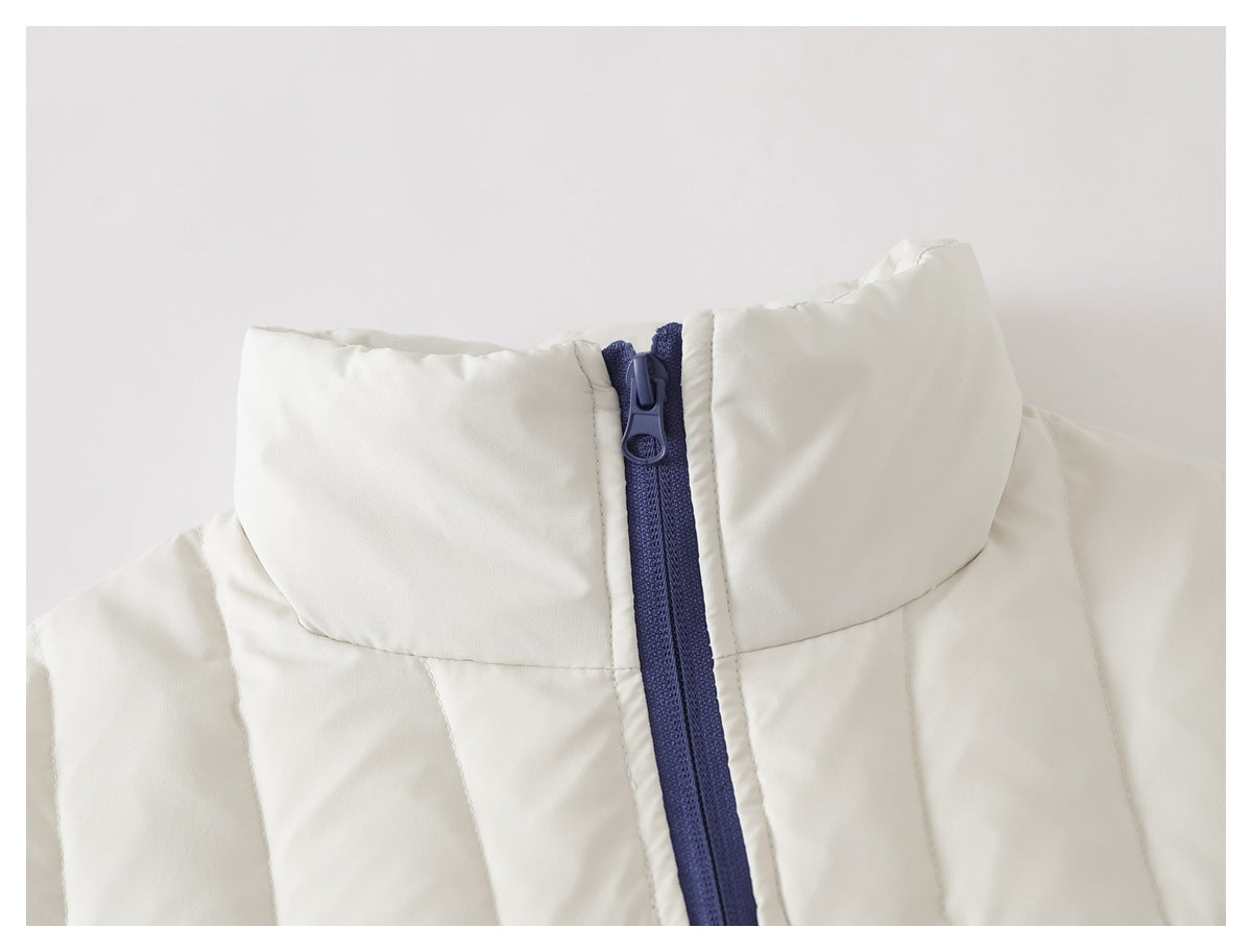Close-up of an ivory quilted jacket's tall collar and dark blue front zipper.