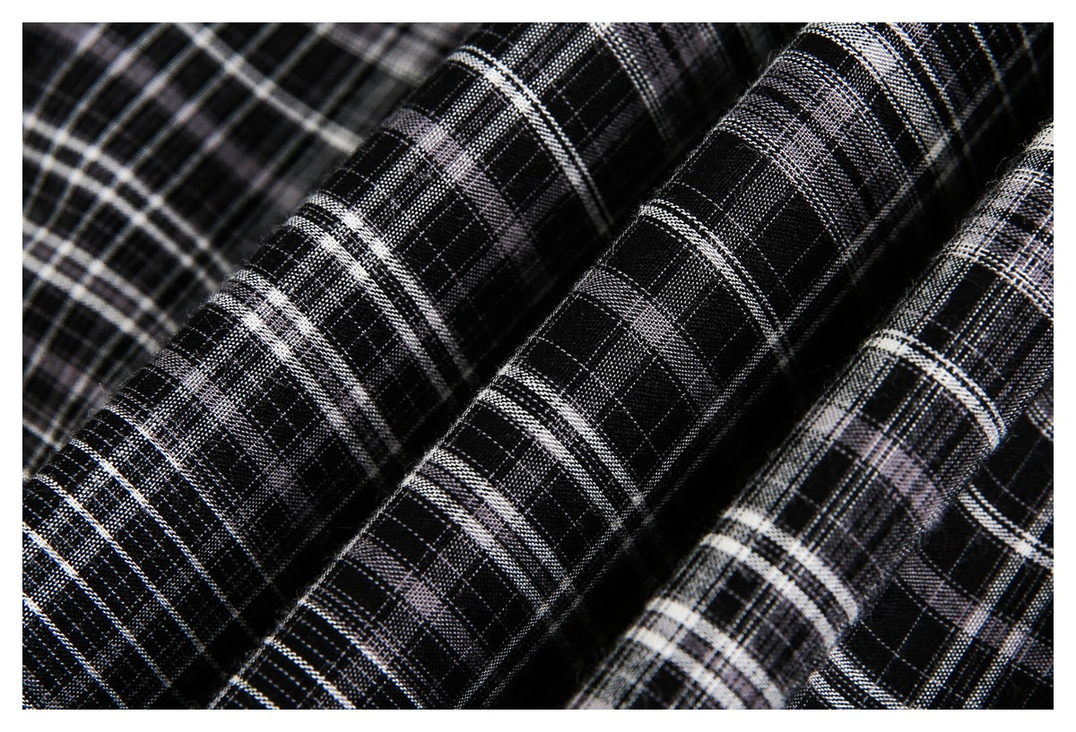 Macro view of black, white, and gray plaid fabric draped in folds.