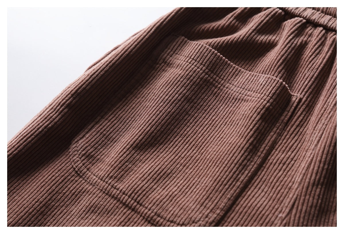 Close-up of a large patch pocket on dusty mauve-brown ribbed trousers.