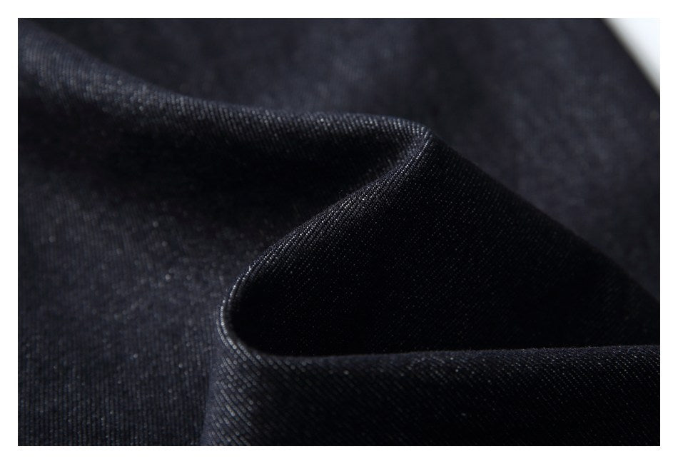Close-up of dark denim fabric folded to show its weave and texture.