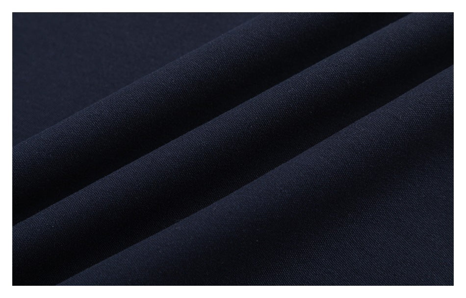 Extreme close-up of navy fabric draped in soft folds, showing its surface texture.