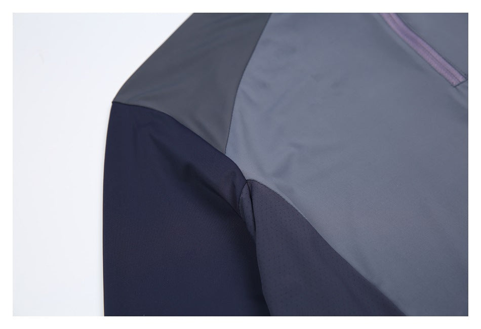 Close-up of the top’s shoulder and underarm, showing gray, navy, and perforated panels.