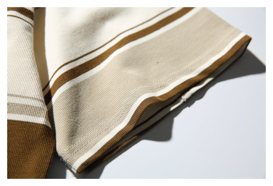 Close-up of a cream-and-brown striped sleeve cuff with a wide cream band and stitched hem.
