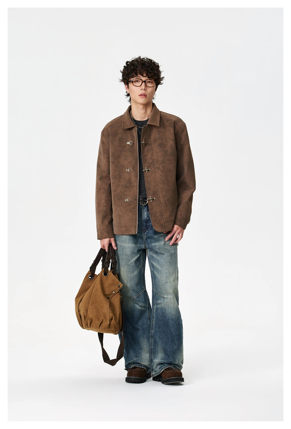 Full-length front view of a model wearing a mottled brown clasp-front jacket and loose blue jeans.