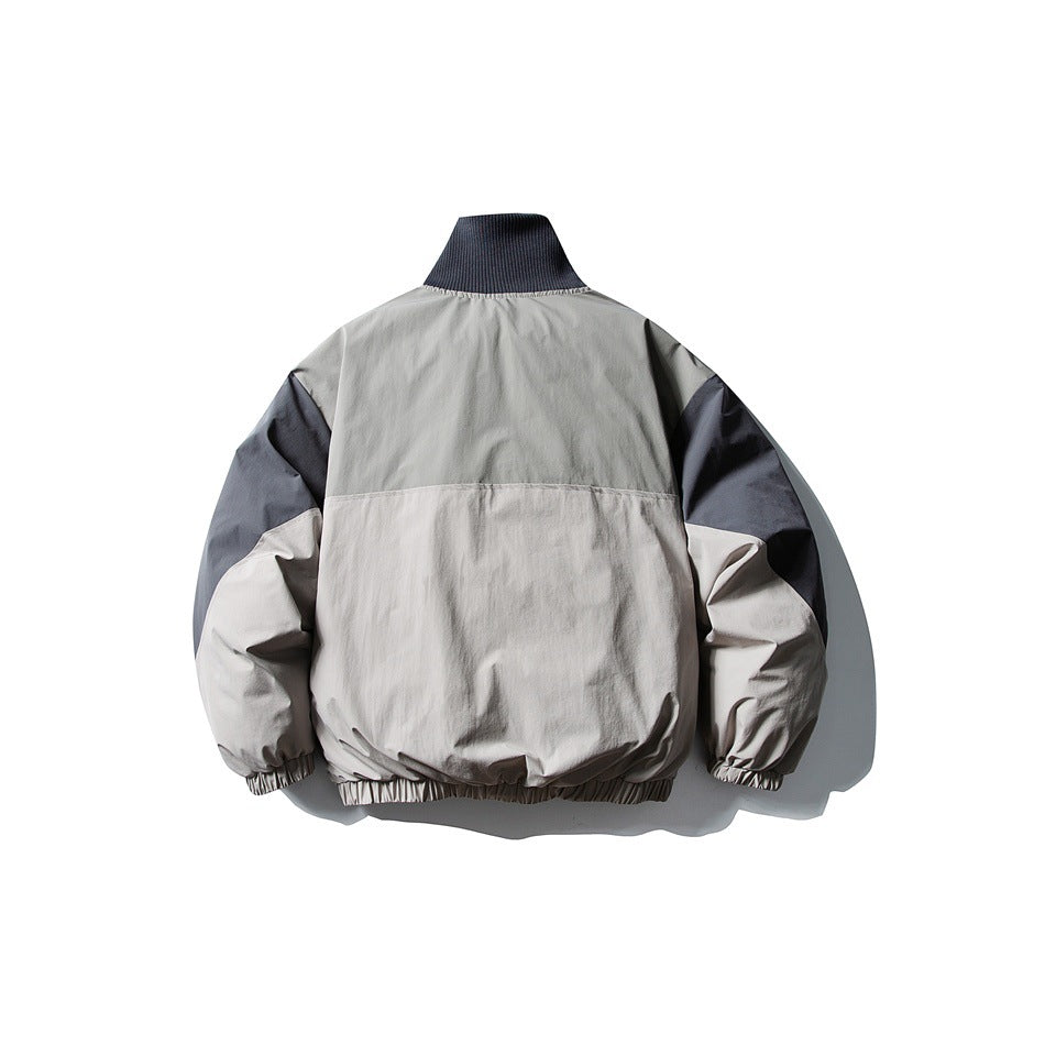 Back view of a color-block jacket with a dark ribbed collar, gray upper panels, dark sleeves, and a light body.