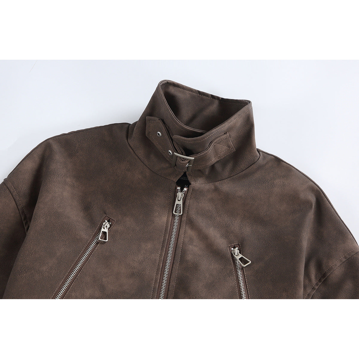 Close-up of a brown jacket’s stand collar, buckle strap, center zipper and two angled zip pockets.