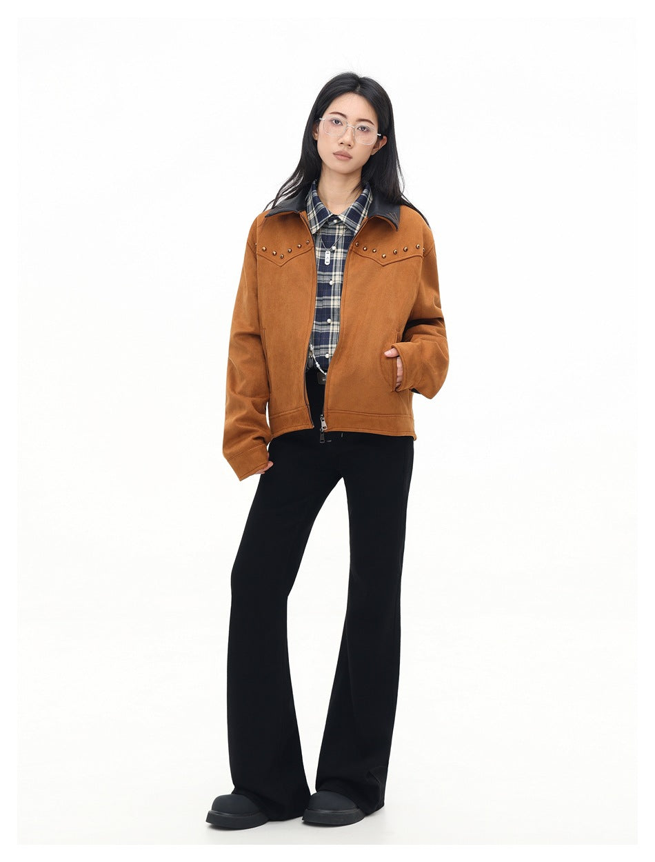 Full-length view of a model in the brown studded jacket with plaid shirt, black flared pants and black shoes
