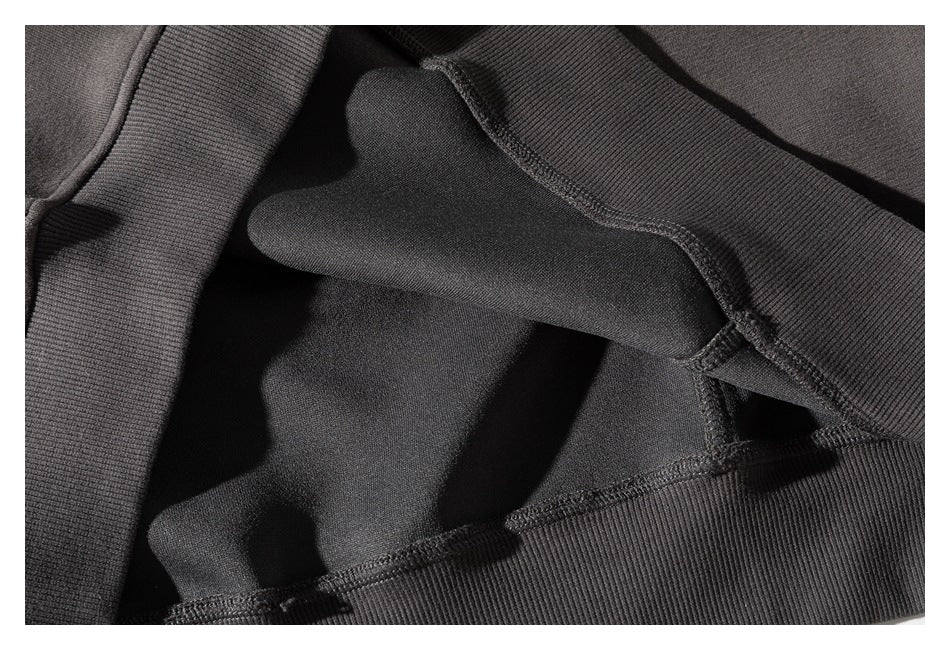 Close-up of a sweatshirt's inside seams and ribbed neckline, showing the interior construction.