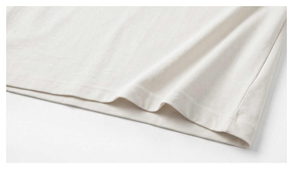 Close-up of the stitched hem and folded edge of a white garment.