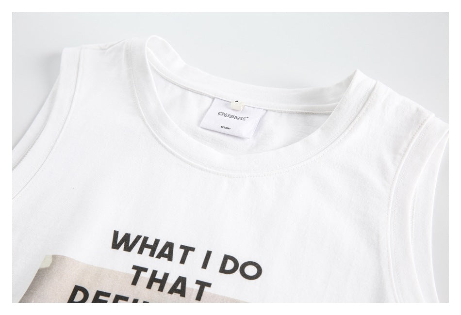 Close-up of a white sleeveless top’s crew neckline and neck label, with part of its black front print visible.
