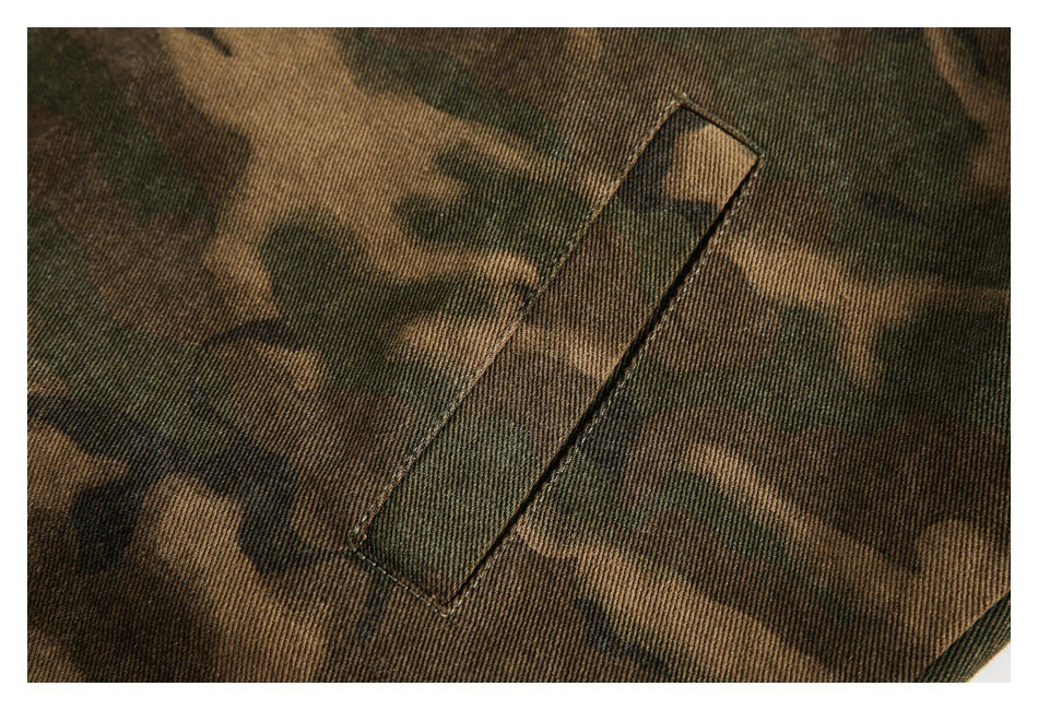 Close-up of a narrow welt pocket stitched into brown and olive camouflage fabric.