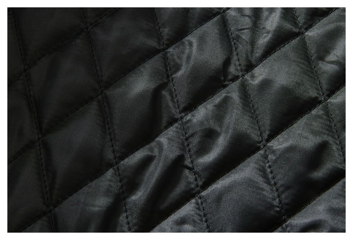 Close-up of black quilted jacket lining with diagonal stitching.