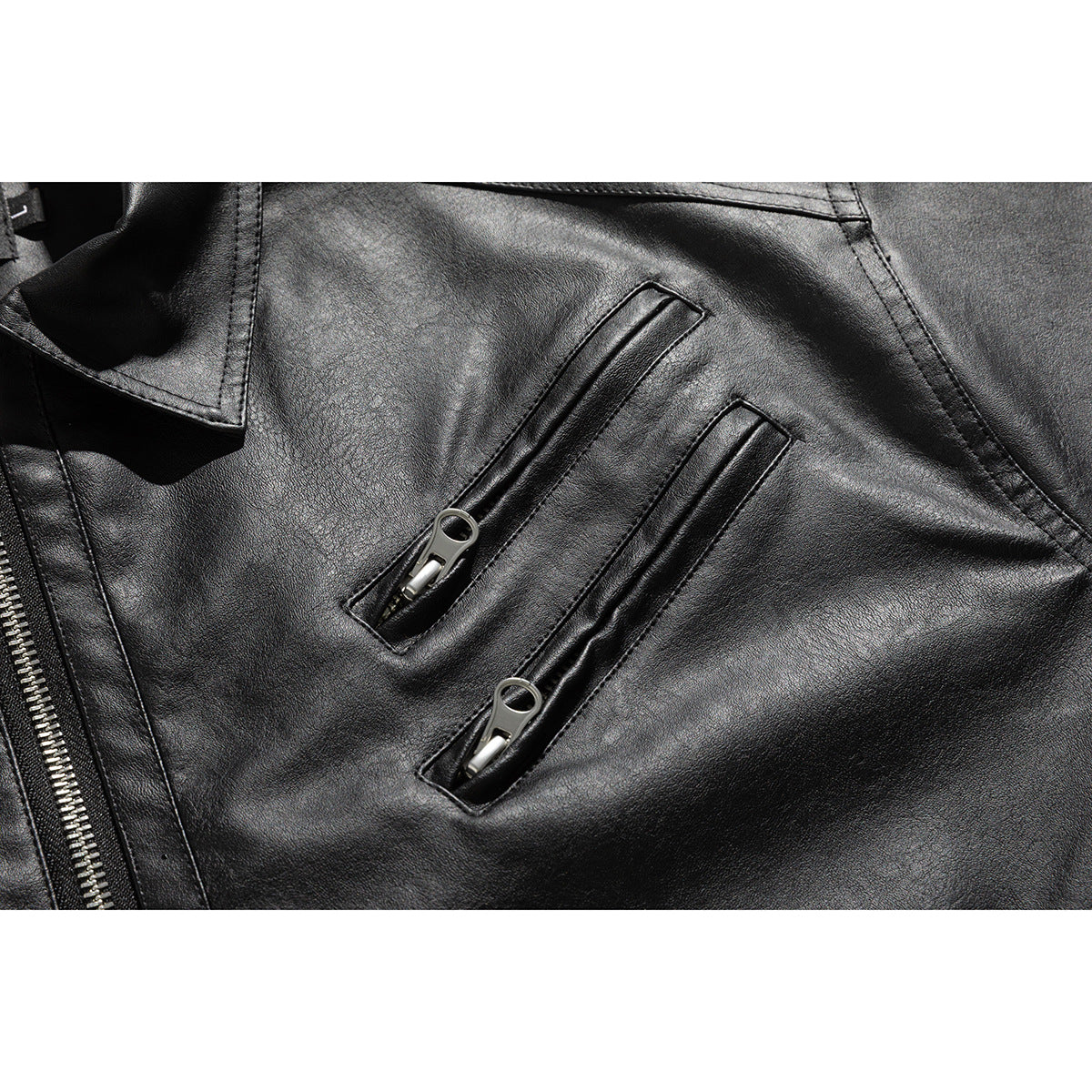 Close-up of two narrow vertical zip pockets on the front of a black jacket.