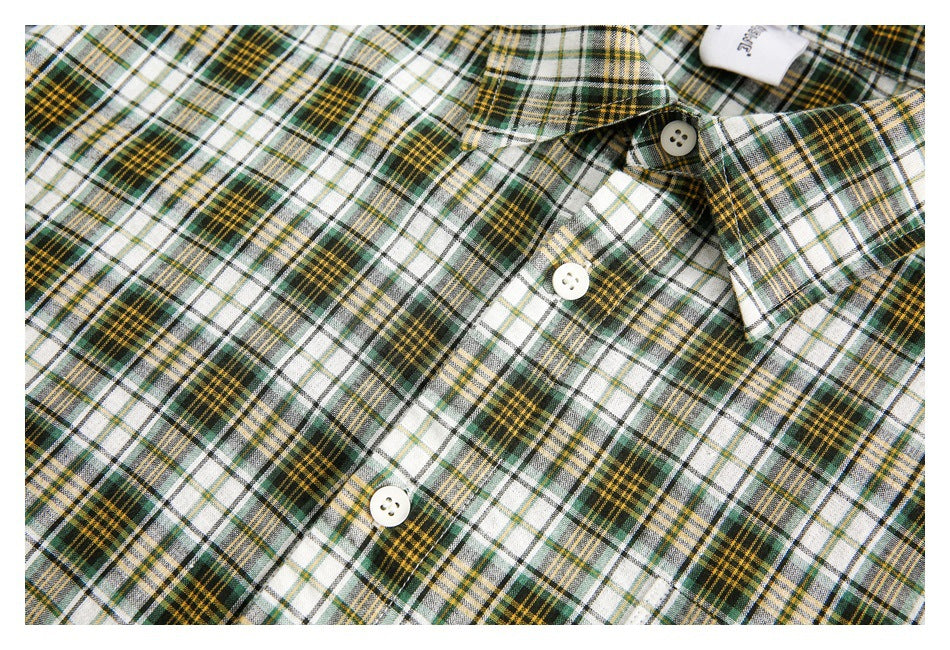 Close-up of the plaid shirt's collar and white buttons along the front placket.