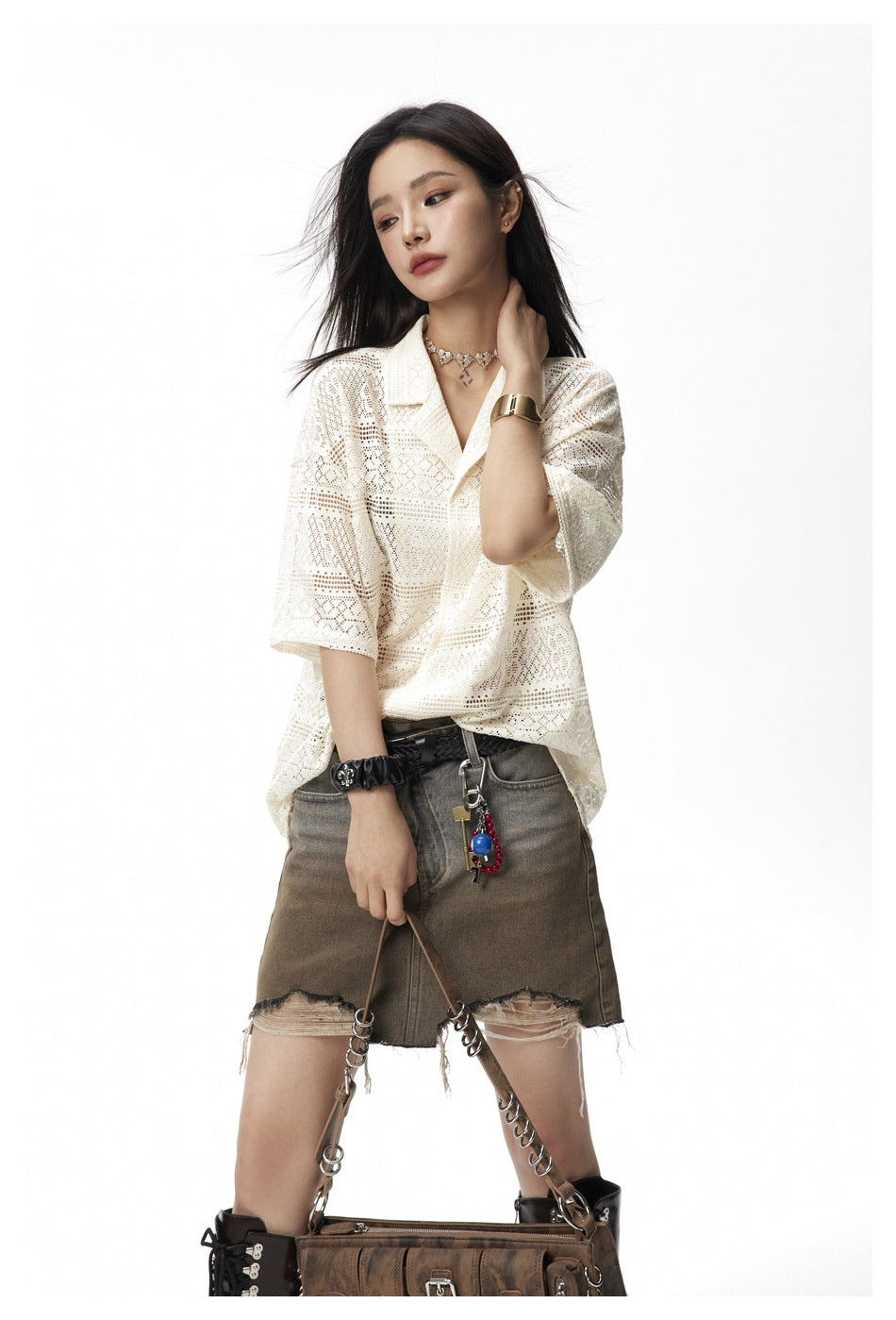 Model wearing an ivory patterned short-sleeve collared shirt and a distressed gray denim mini skirt.