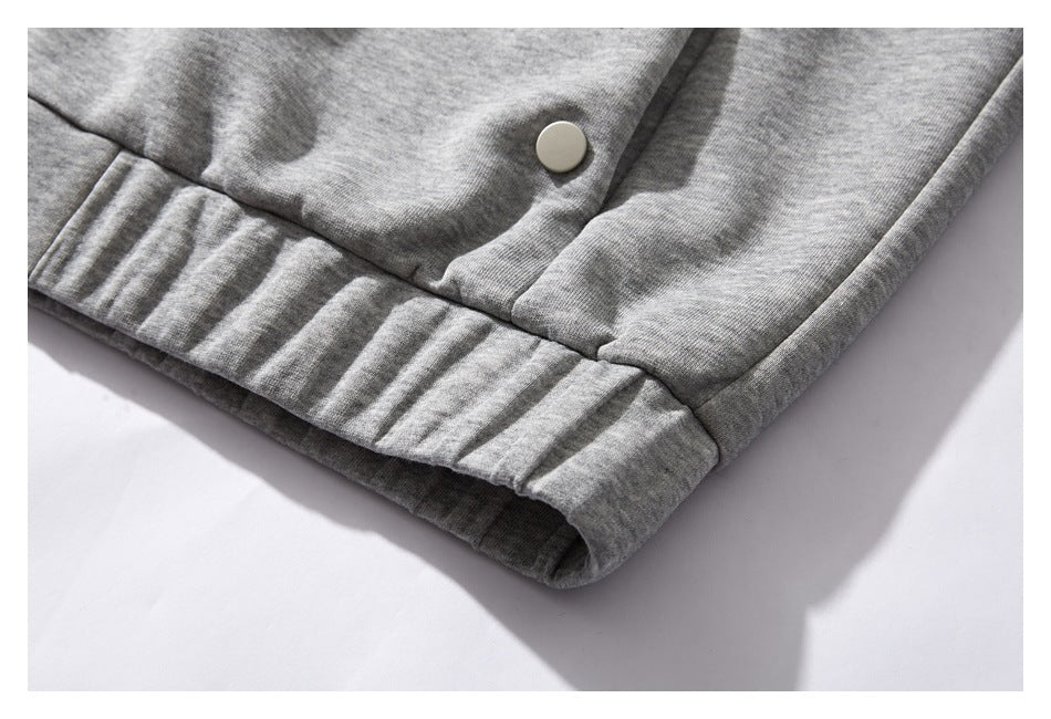 Close-up of the heather gray jacket's ribbed bottom hem and a metal snap.