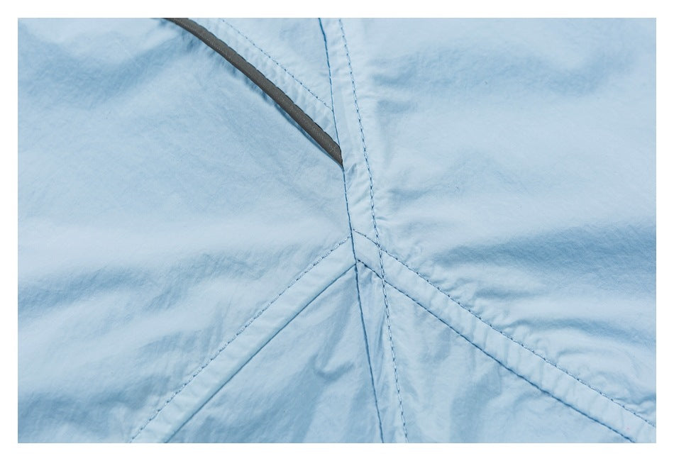 Close-up of pale blue garment fabric with intersecting stitched seams and dark gray edge trim.