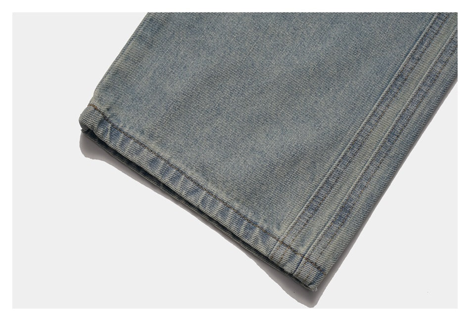 Close-up of a light-wash blue denim trouser leg hem with double-row stitching.