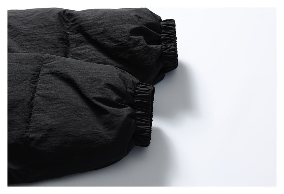 Close-up of two black jacket sleeves with gathered elastic cuffs.