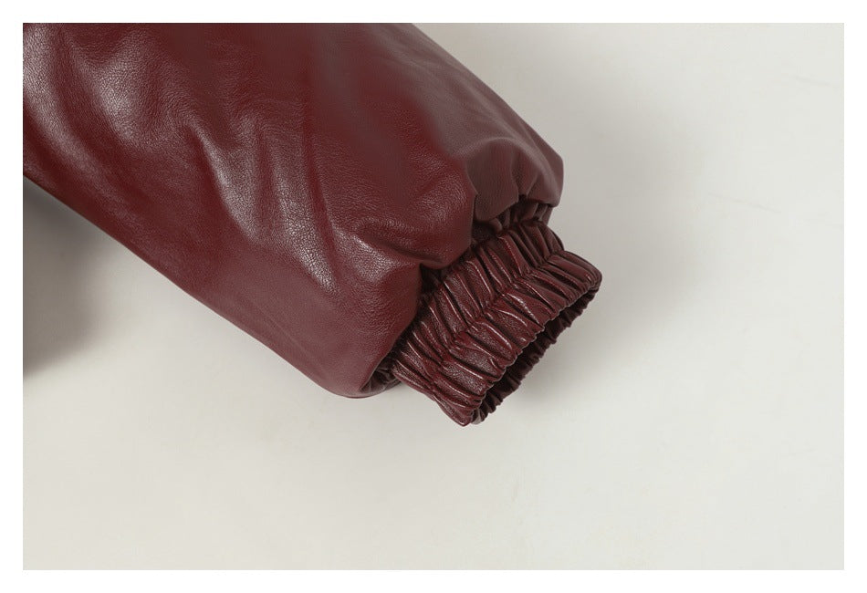 Close-up of a burgundy jacket sleeve with a gathered elastic cuff.