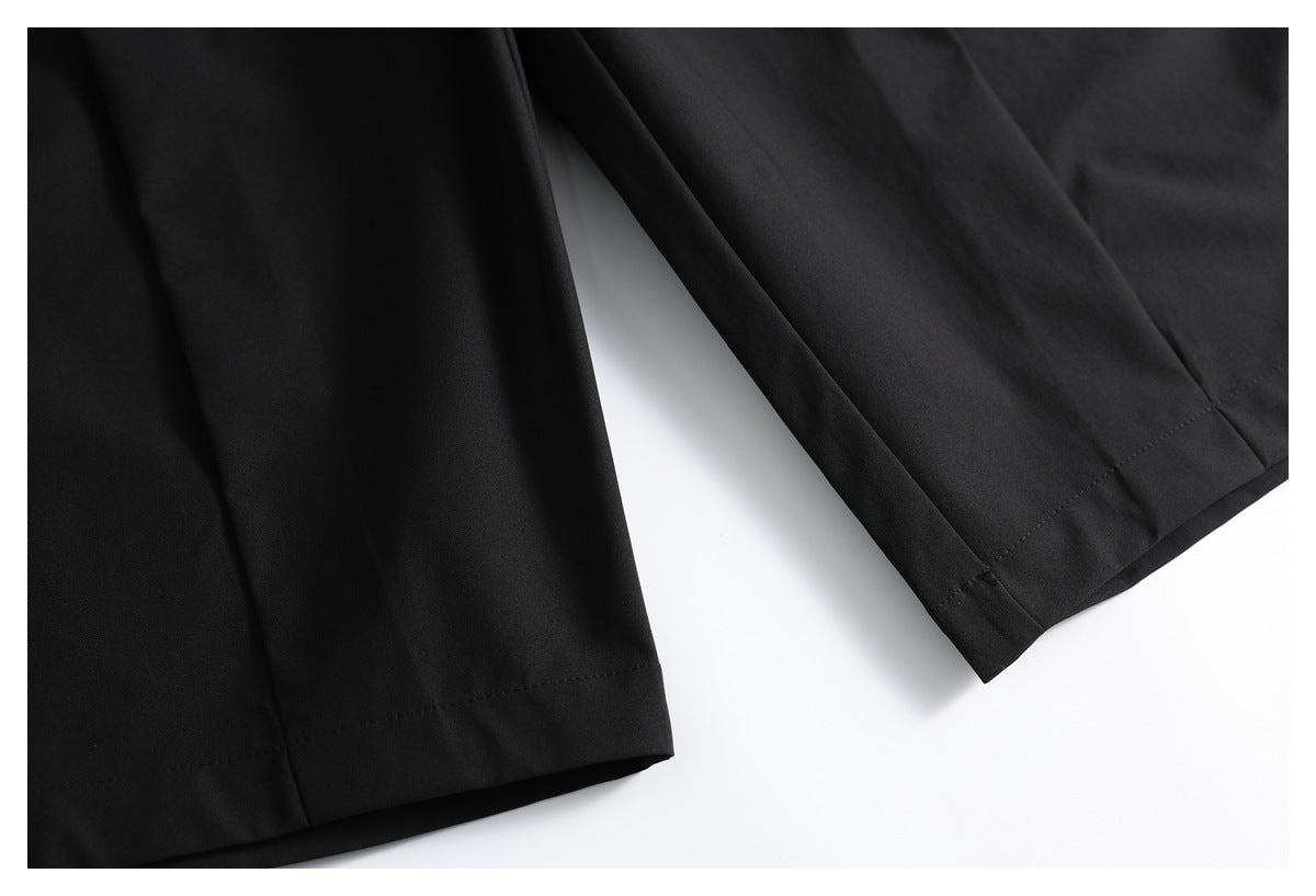 Close-up of black trouser legs showing stitched hems.