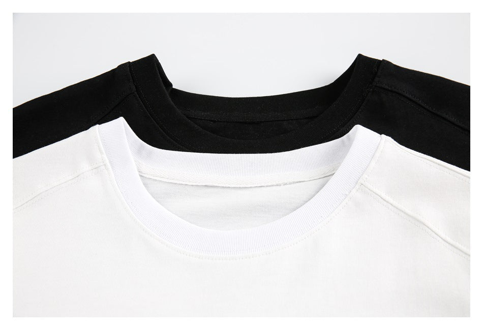 Close-up of overlapping black and white T-shirt crew necklines and shoulder seams.