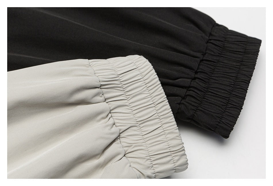 Close-up of gathered elastic cuffs in black and light gray fabric.