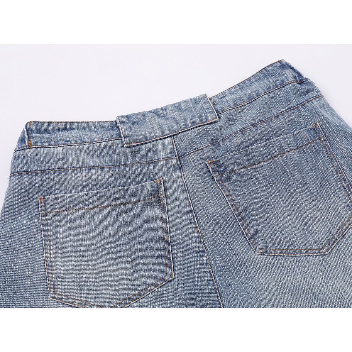 Close-up of the back waist and two pockets on faded blue jeans.