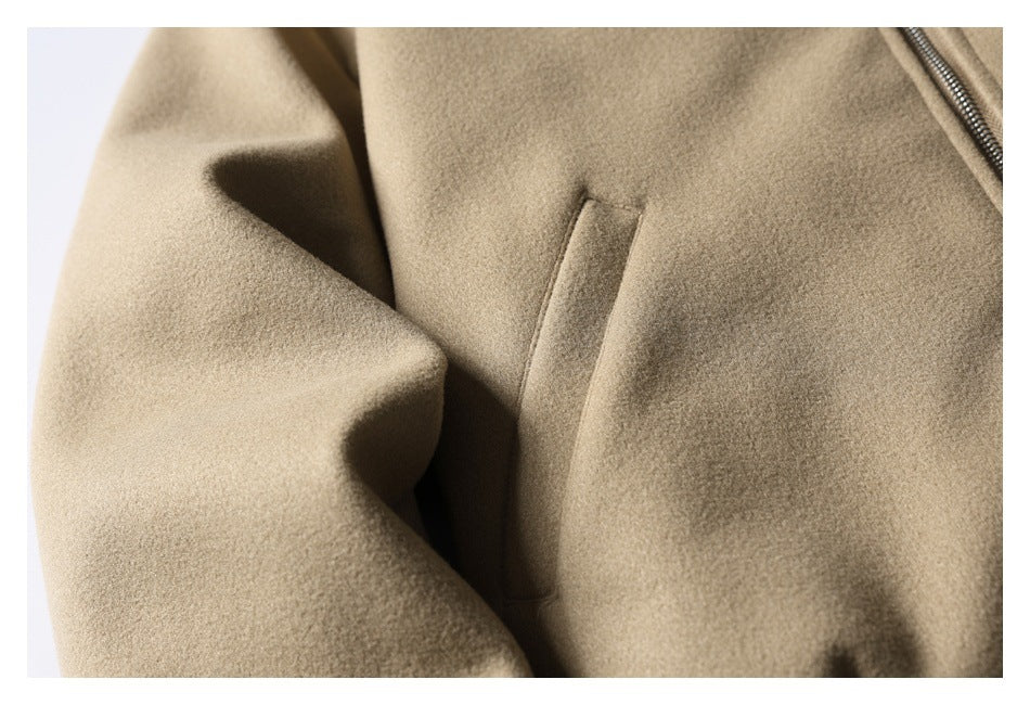 Close-up of a vertical welt pocket on the taupe jacket, with part of the front zipper visible.