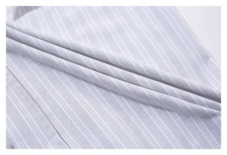 Close-up of pale gray fabric with thin white stripes, softly draped to show its surface and folds.