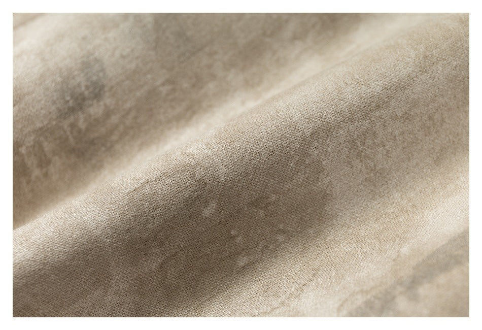 Extreme close-up of the beige mottled jacket fabric and its surface texture.