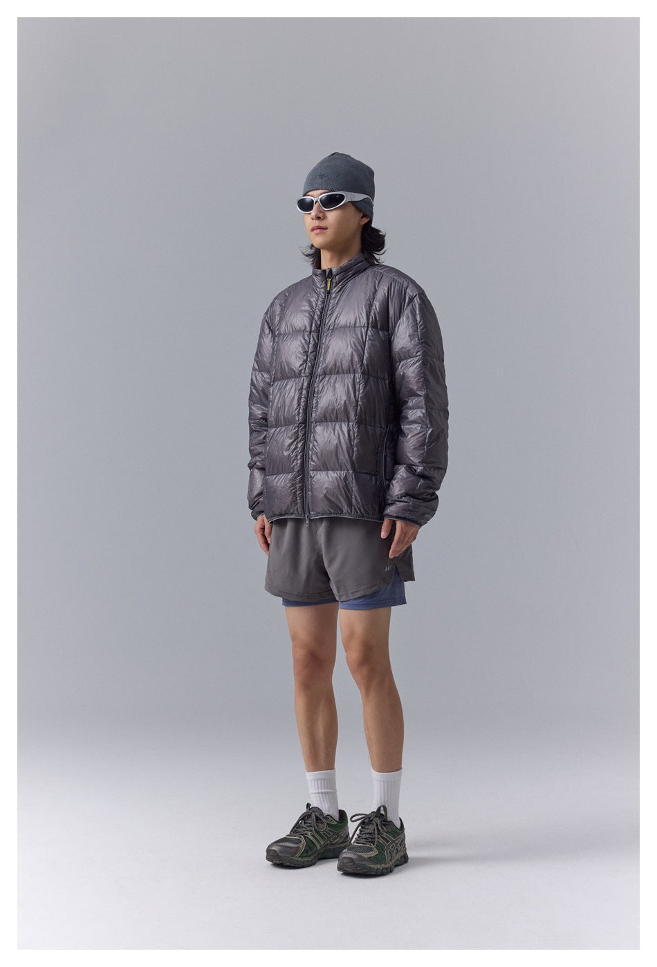 Model wearing a charcoal gray quilted zip jacket, shown from the front.
