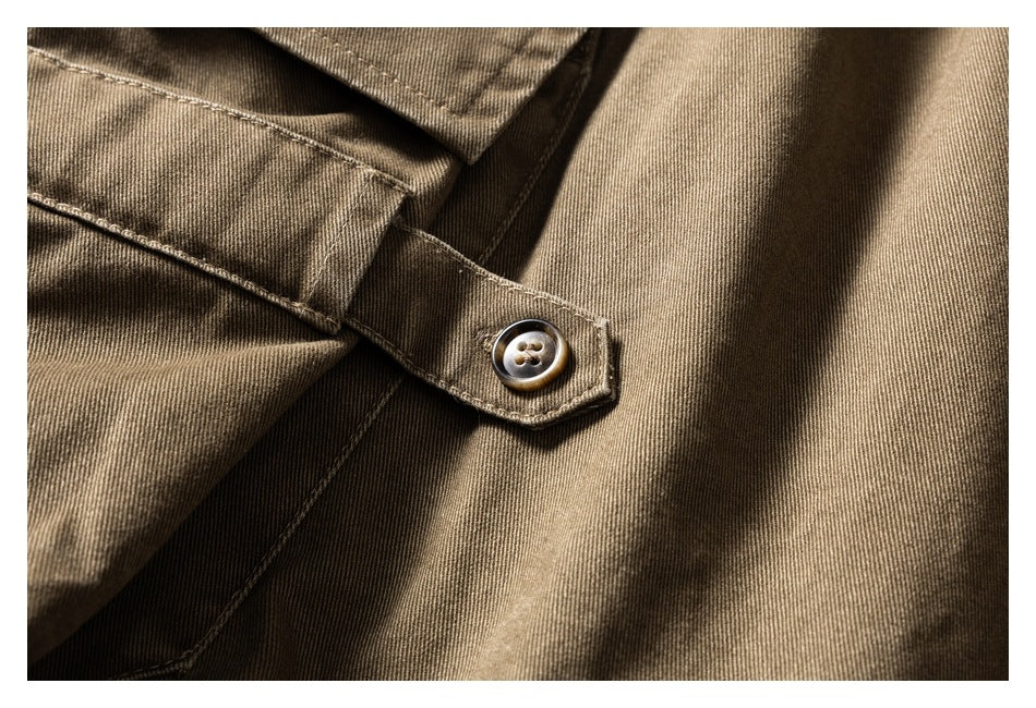 Close-up of a brown button fastening a tab on khaki-brown fabric.