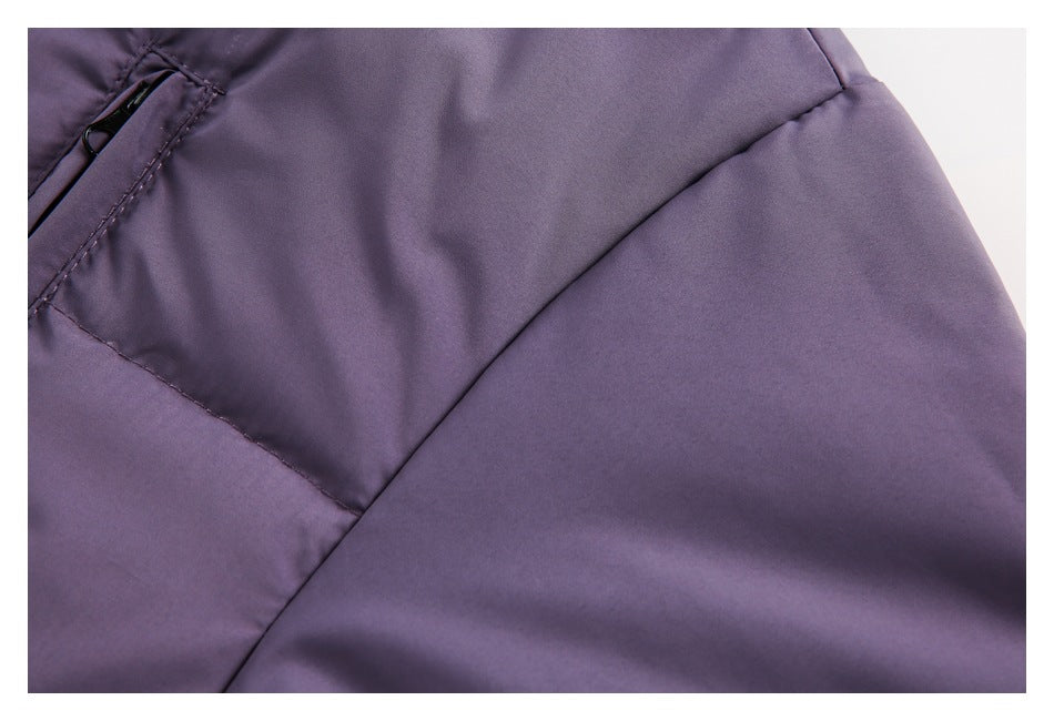 Close-up of purple garment panel seams beside a partially visible zip pocket.