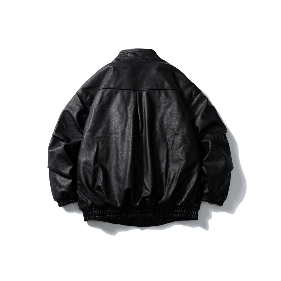 Back view of a black jacket with a shoulder yoke, center pleat, and elastic cuffs and hem.