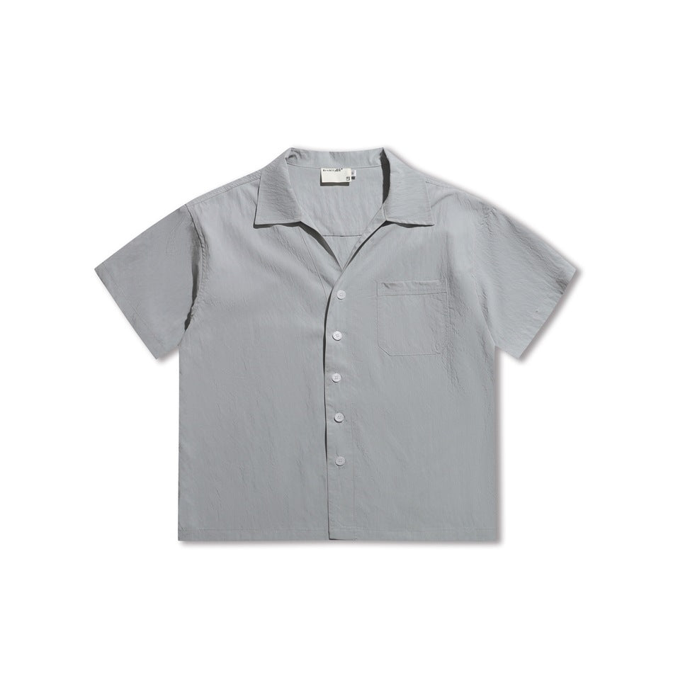 Ice blue short-sleeve button-front shirt with camp collar and chest pocket, flat lay front view