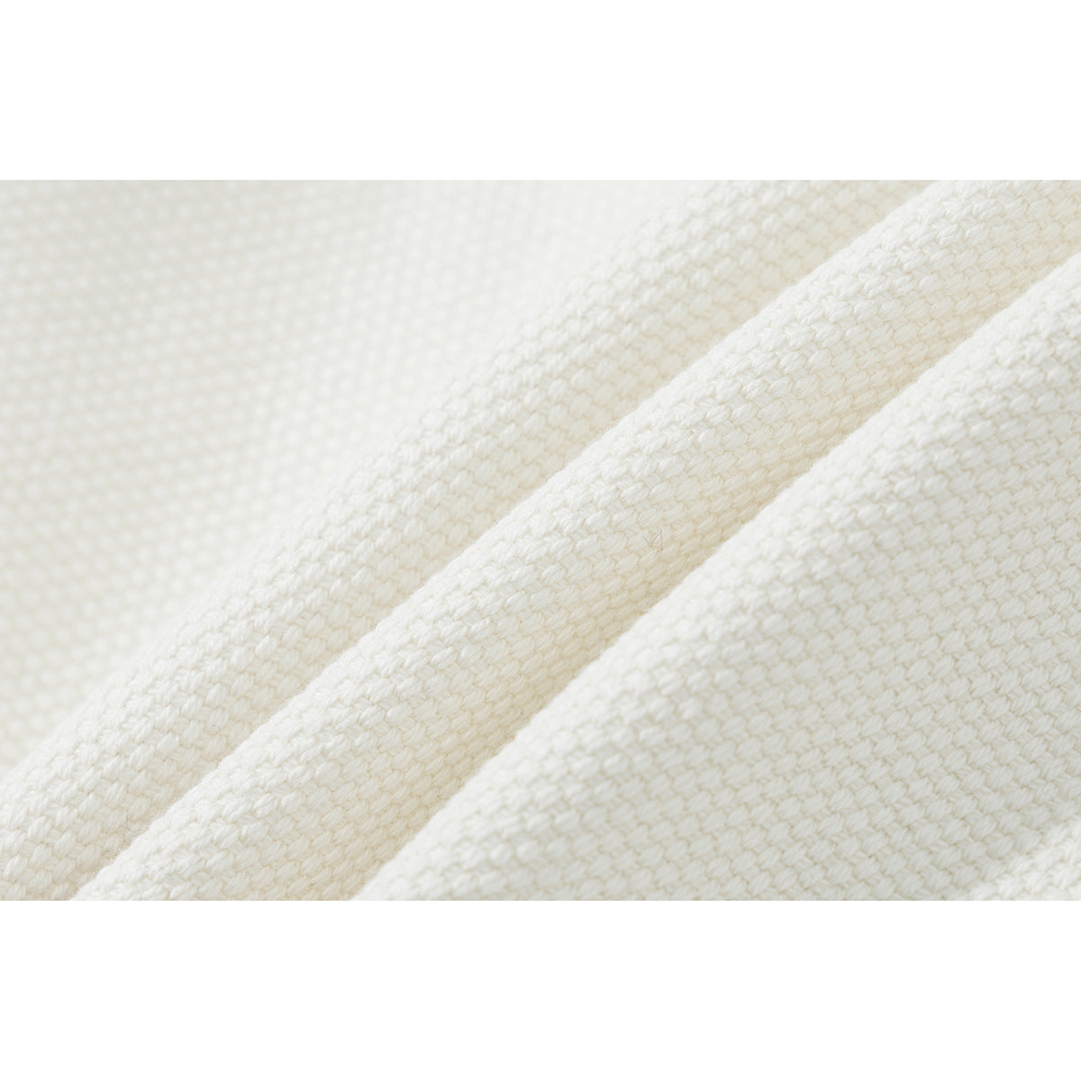 Macro view of the ivory shorts' textured woven-looking surface and folded seam.