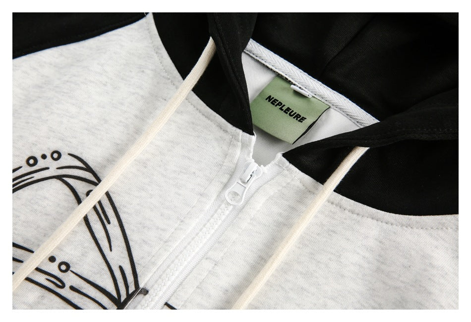 Close-up of a white zipper, cream drawstrings, black hood lining, and partial octopus artwork on a heather gray hoodie.