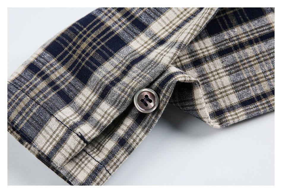 Close-up of navy, cream, and tan plaid fabric with a dark four-hole button.