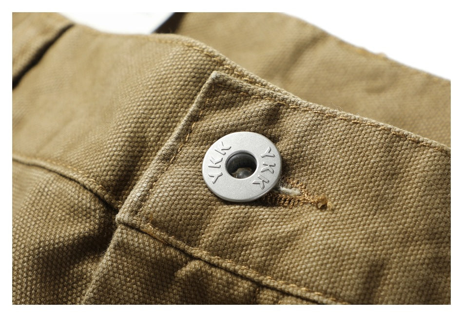 Close-up of a metal button on the textured khaki waistband.