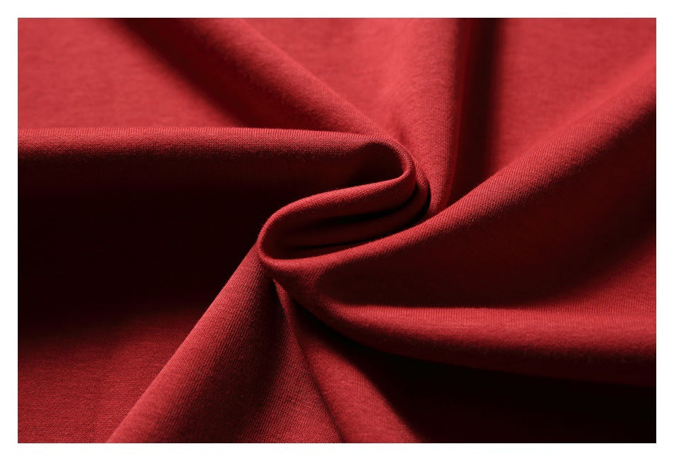 Close-up of red T-shirt fabric gathered into soft folds.
