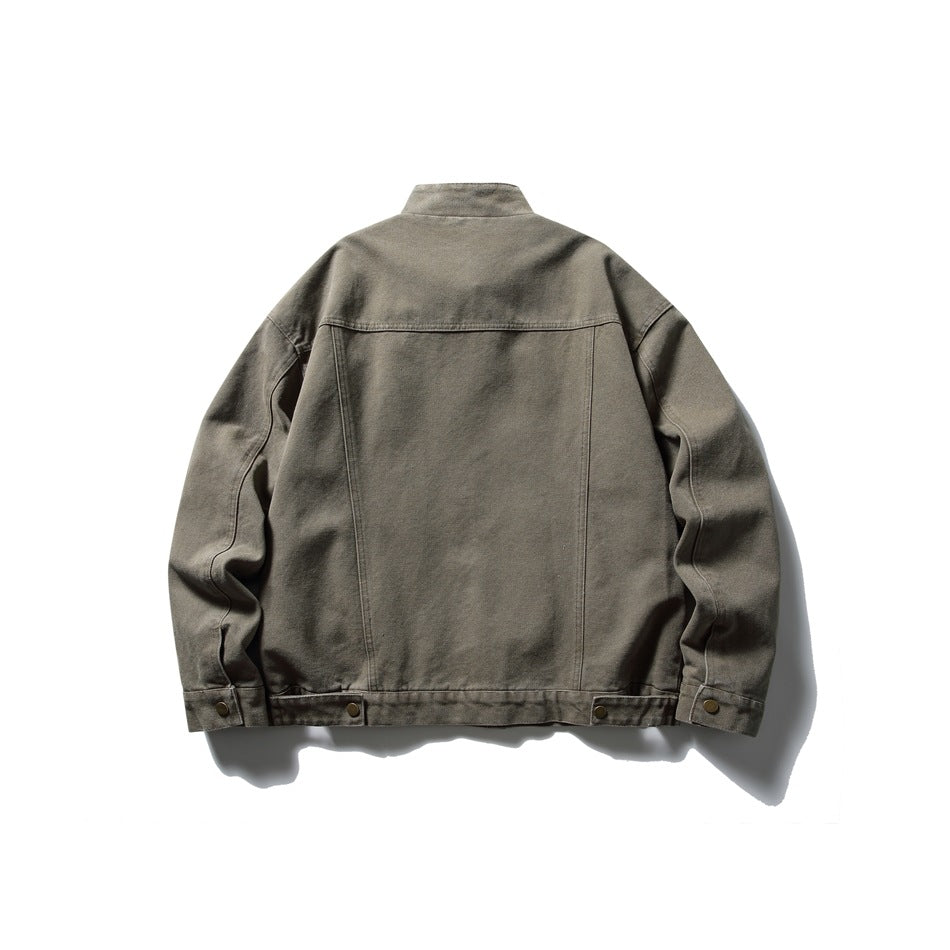 Back view of green stand-collar jacket showing yoke seam, vertical seams and snap tabs at hem and cuffs