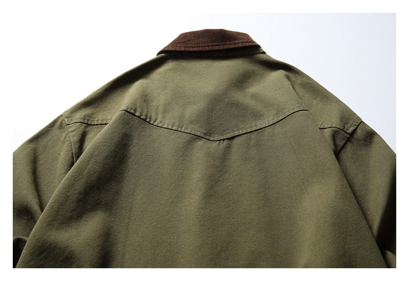 Close view of an olive jacket's upper back, with a curved seam and dark brown collar.