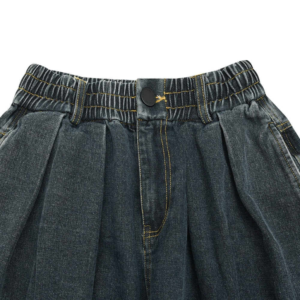Close-up of the pants' elastic front waistband, button, fly stitching, and pleats.