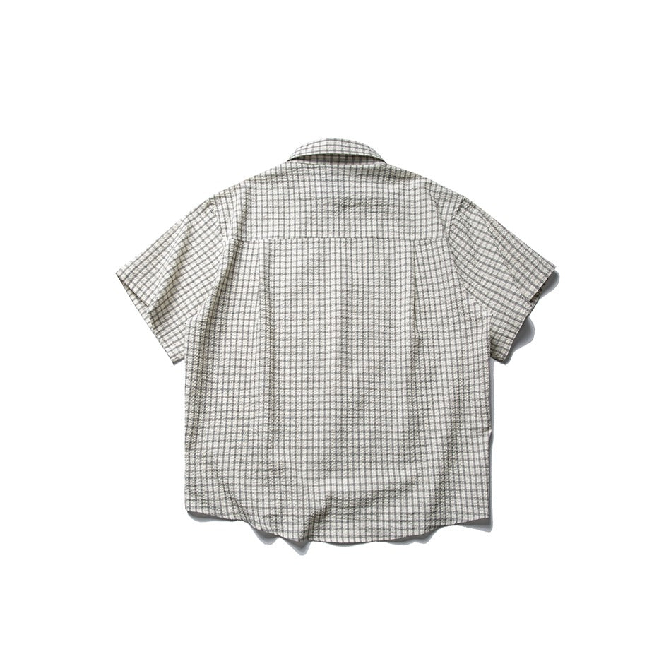 Back view of a beige short-sleeve button-up shirt with a small dark check pattern.