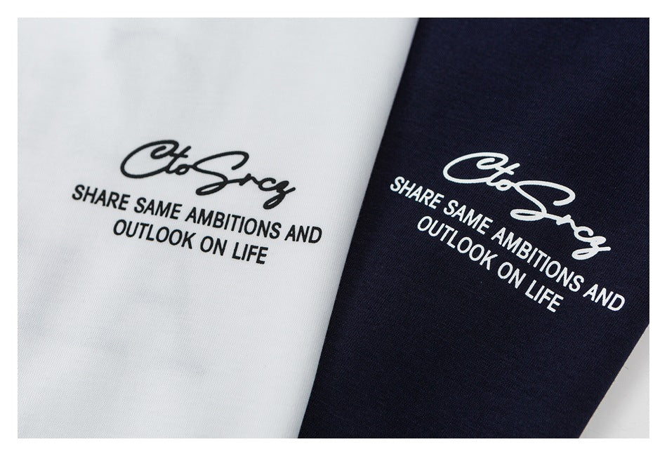 Close-up of black and white slogan prints on white and navy T-shirt fabric.