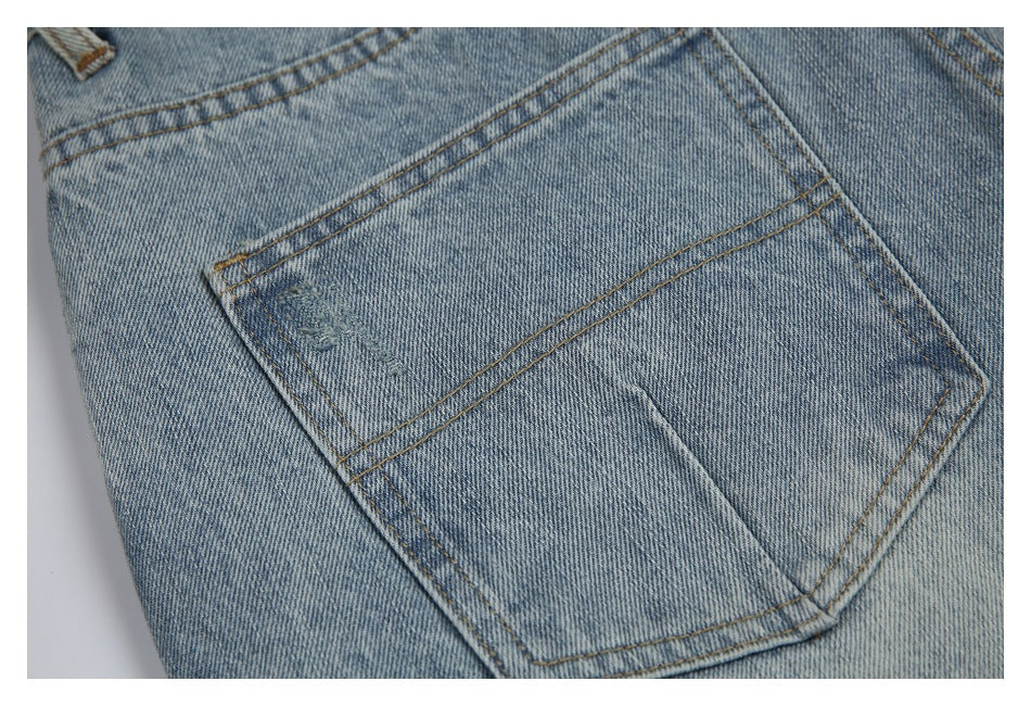 Close-up of a stitched back pocket on light-wash denim jeans.