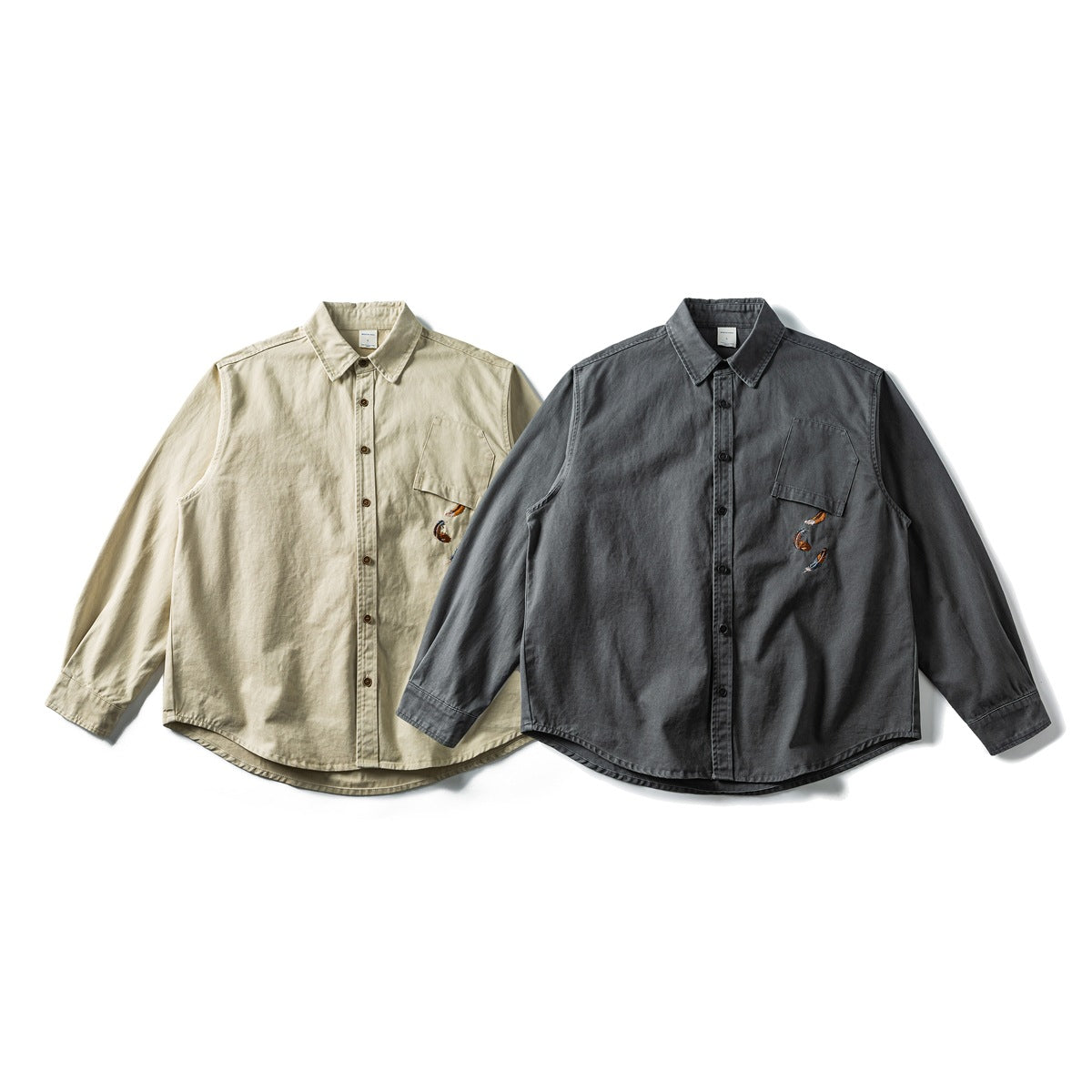 Front view of two long-sleeve button-up shirts in beige and charcoal, each with a chest pocket and feather embroidery.
