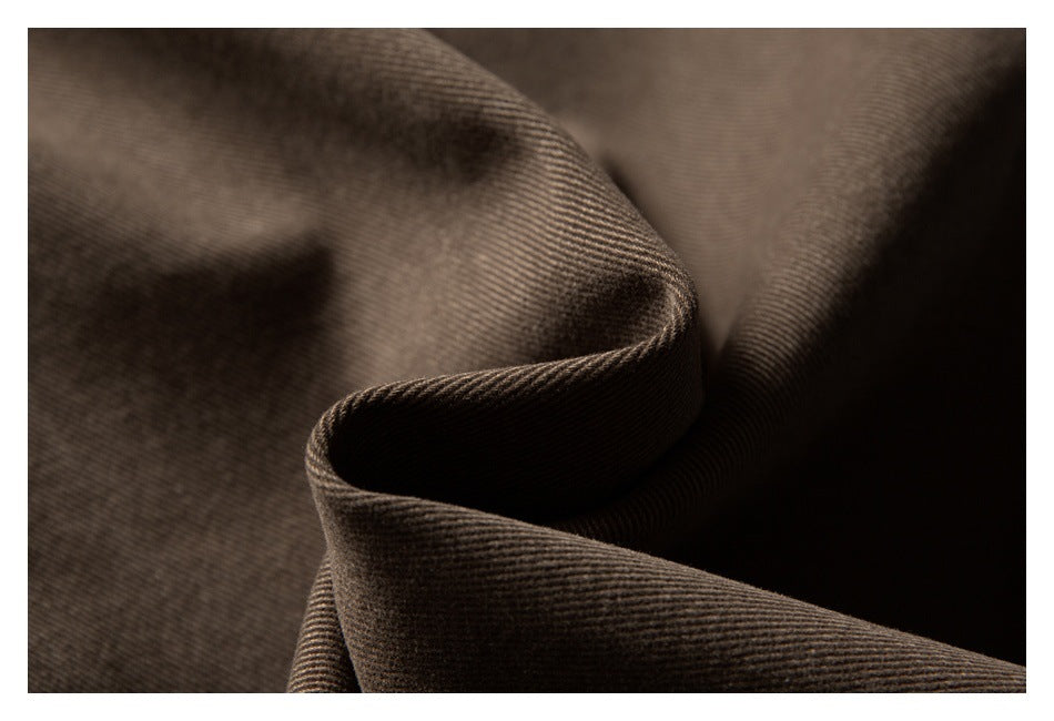 Macro view of brown fabric folded to show its fine diagonal weave.