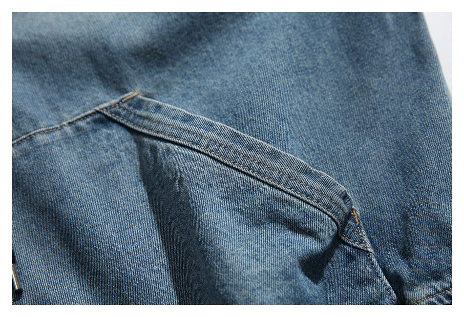 Close-up of a blue denim jacket pocket with contrast stitching.